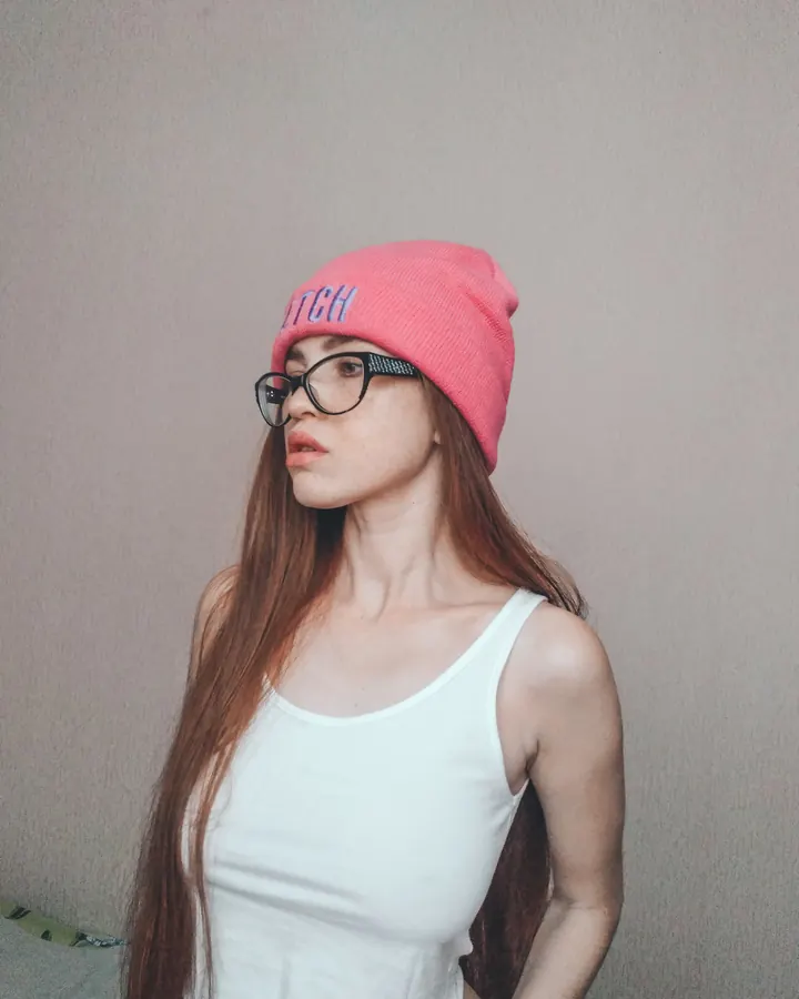 Femme aux cheveux bruns, vêtue d’un haut noir et d’un short en jean, marchant en ville, lunettes de soleil