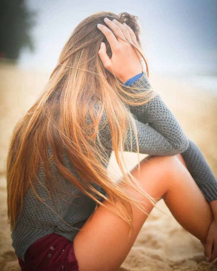 Femme aux cheveux roux, peau blanche, regard direct, pose frontale dans un cadre sombre