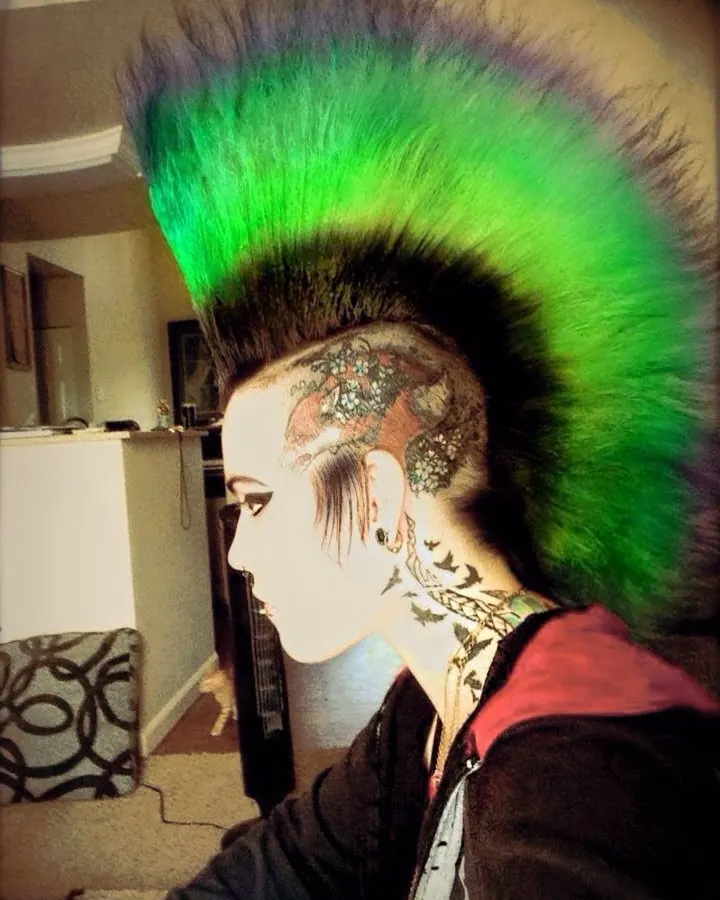 Femme aux cheveux roux, peau blanche, regard direct, pose frontale dans un cadre sombre